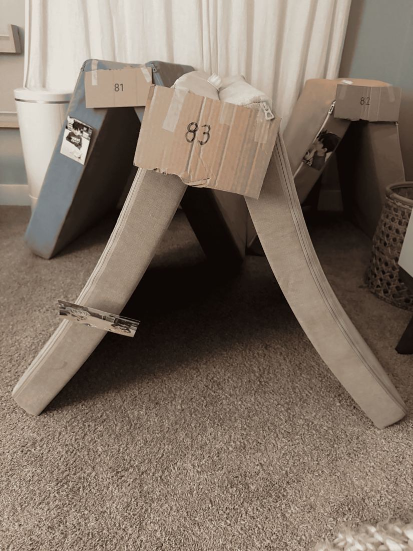 Room 83: a beige cushion tent with a cardboard sign reading 83